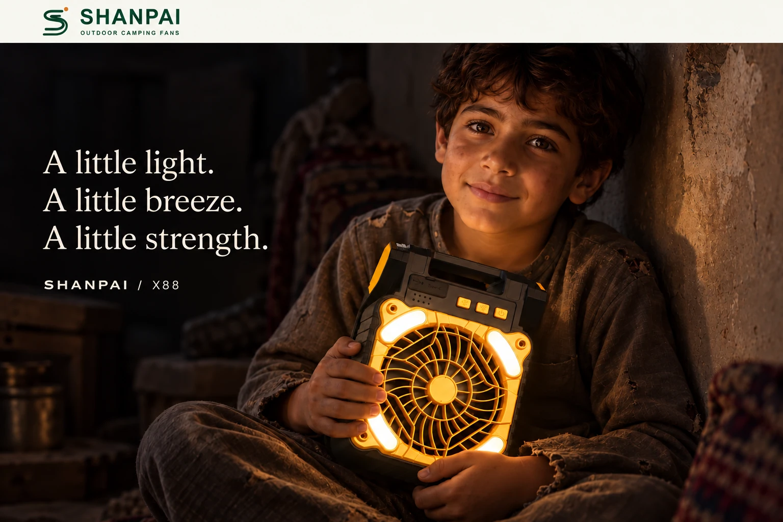 A boy holding an X88 fan, his face illuminated by warm light